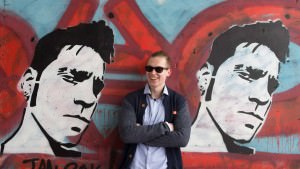 Patrick standing in between graffiti art